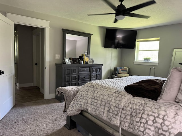 carpeted bedroom featuring a textured ceiling, ceiling fan, and baseboards