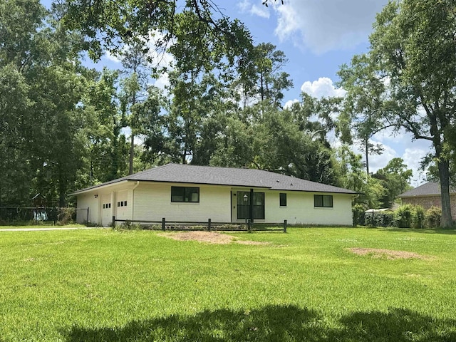 rear view of house featuring a yard and an attached garage