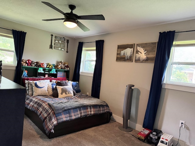 bedroom with ceiling fan, carpet flooring, and baseboards