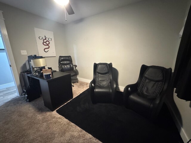 carpeted home office with a ceiling fan and baseboards