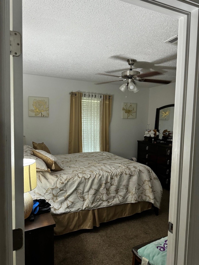 bedroom featuring carpet flooring, a textured ceiling, and ceiling fan