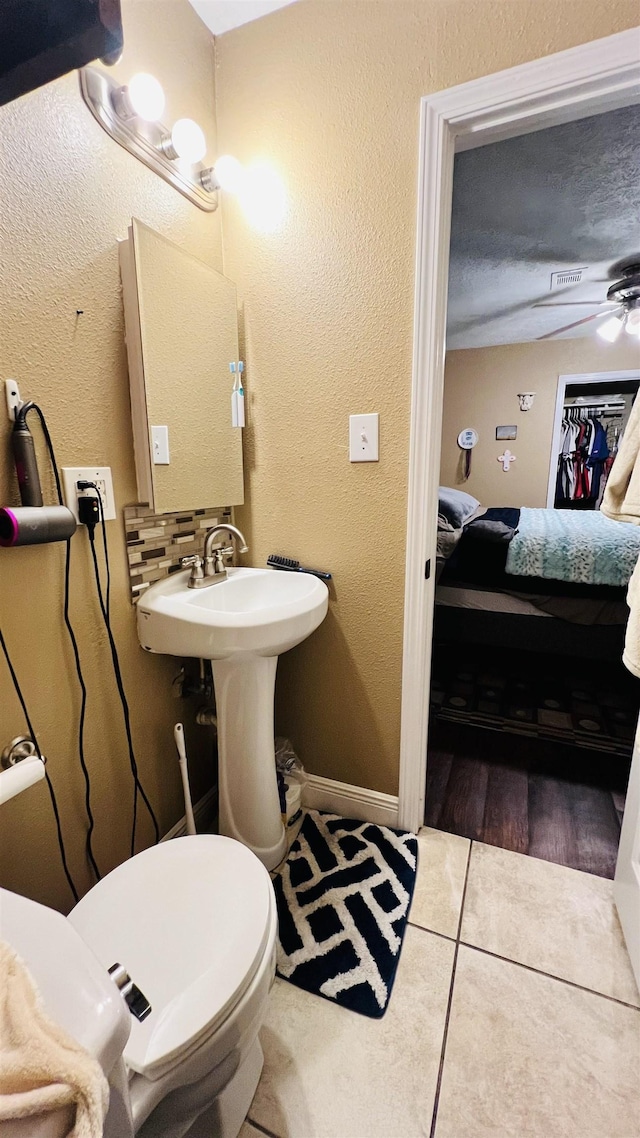 bathroom with tile patterned floors, ceiling fan, toilet, and tasteful backsplash