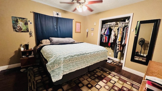 bedroom featuring dark hardwood / wood-style flooring, ceiling fan, a closet, and a textured ceiling