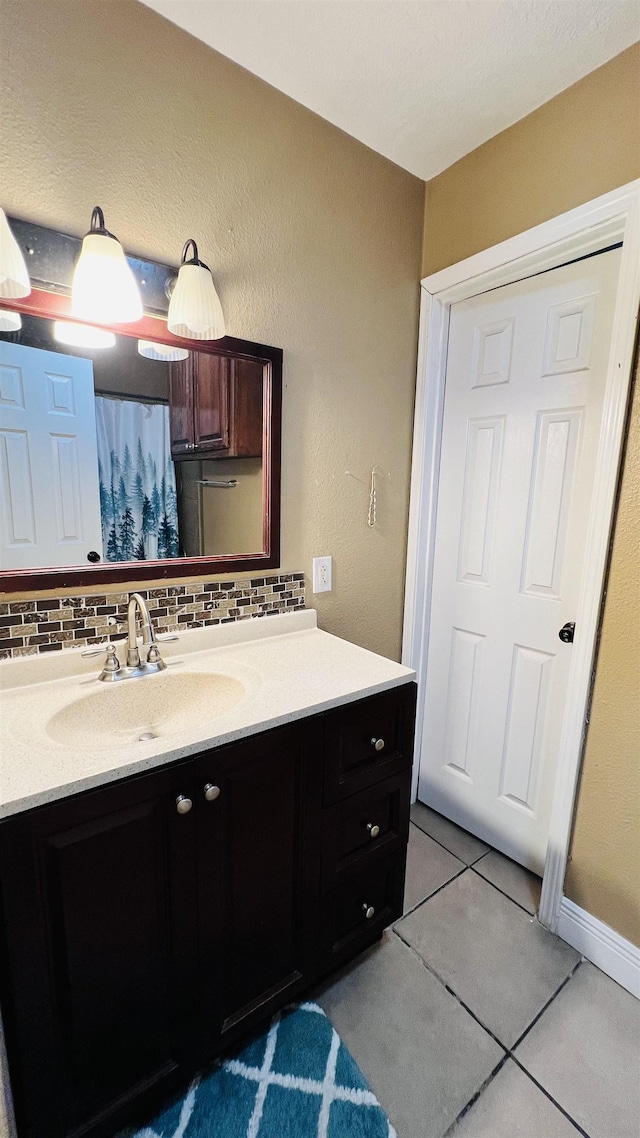 bathroom with backsplash, tile patterned flooring, and vanity