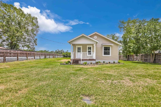 rear view of property with covered porch and a yard