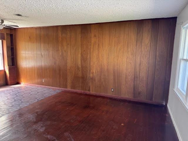 6 Circle Q St, Orange, TX 77630 - spare room featuring wooden walls, wood finished floors, a textured ceiling, and a ceiling fan