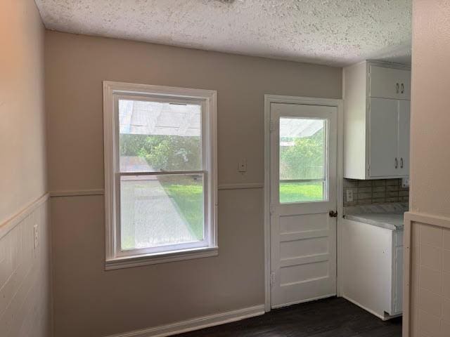 6 Circle Q St, Orange, TX 77630 - doorway to outside featuring a textured ceiling, dark wood finished floors, and a wainscoted wall