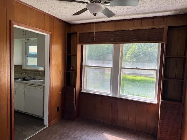 6 Circle Q St, Orange, TX 77630 - unfurnished dining area featuring healthy amount of natural light, wood walls, a sink, a textured ceiling, and ceiling fan