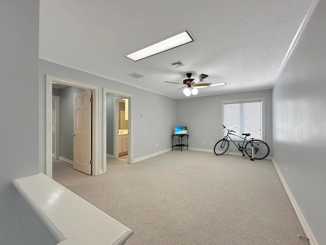 miscellaneous room featuring ceiling fan, light colored carpet, a textured ceiling, and ornamental molding