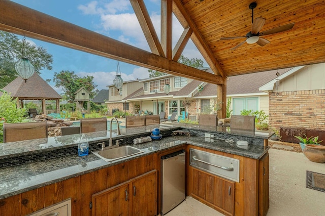 view of patio / terrace featuring a ceiling fan, an outdoor kitchen, a sink, and a gazebo