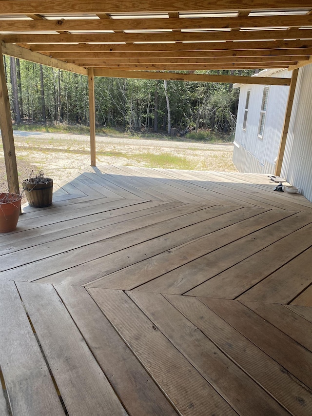 wooden terrace featuring a view of trees