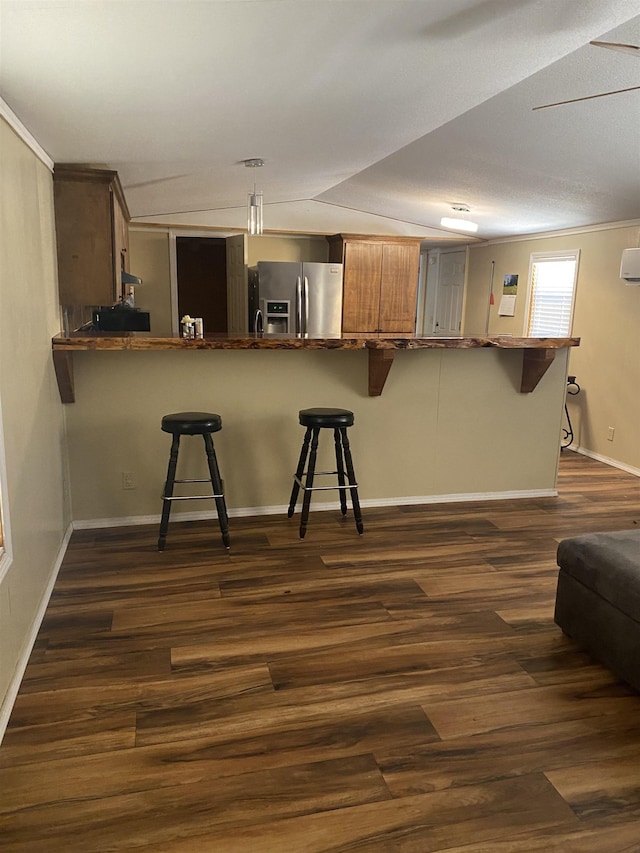 kitchen featuring dark wood-style floors, a breakfast bar, and stainless steel fridge