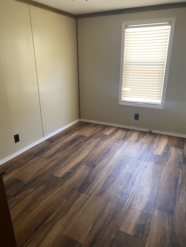 unfurnished room with dark wood-style floors and baseboards