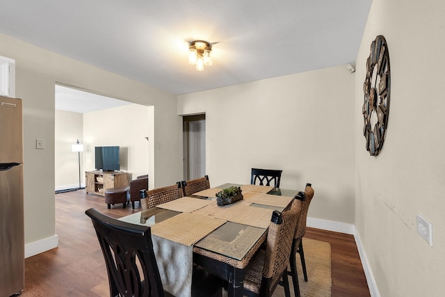 dining area with baseboards and wood finished floors