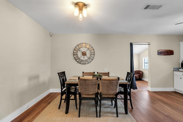 dining space with visible vents, baseboards, and wood finished floors