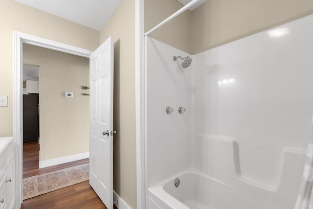 full bathroom featuring baseboards, wood finished floors, and vanity