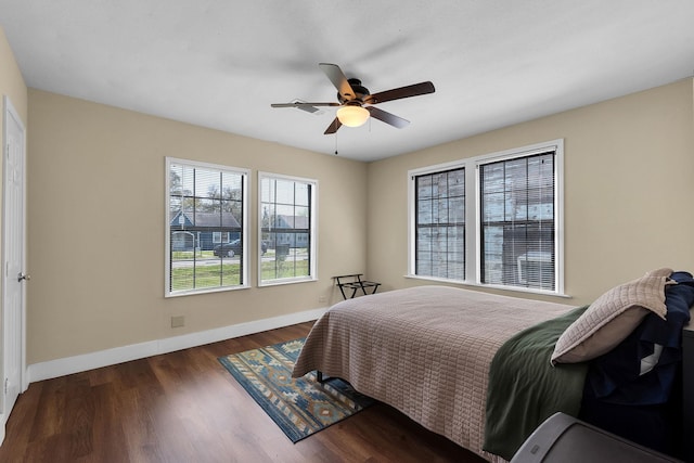 bedroom with baseboards, wood finished floors, and a ceiling fan