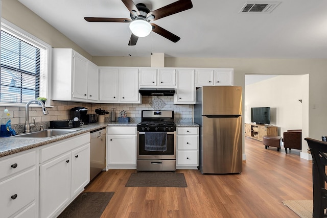 kitchen featuring a ceiling fan, visible vents, a sink, under cabinet range hood, and appliances with stainless steel finishes