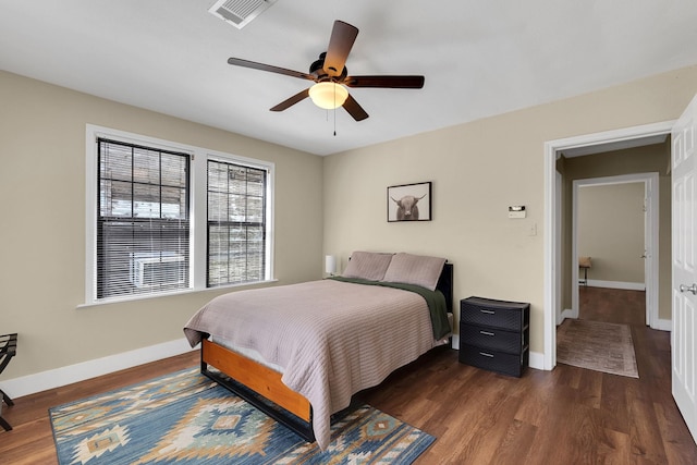 bedroom with visible vents, a ceiling fan, baseboards, and wood finished floors