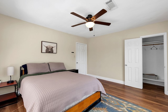 bedroom featuring ceiling fan, visible vents, baseboards, and wood finished floors