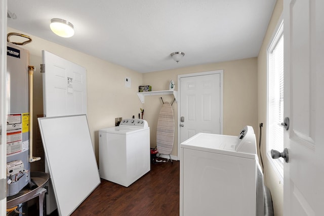 washroom with water heater, laundry area, washing machine and dryer, and dark wood-style flooring