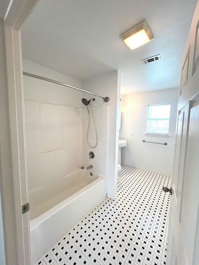 bathroom featuring shower / bathtub combination and toilet