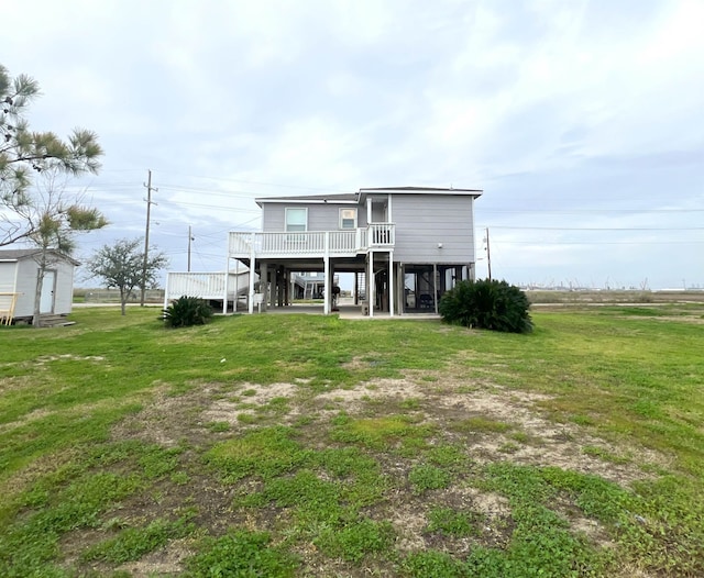 back of house featuring a wooden deck, a yard, and a carport