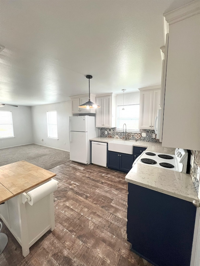 kitchen with white cabinets, sink, white appliances, and hanging light fixtures