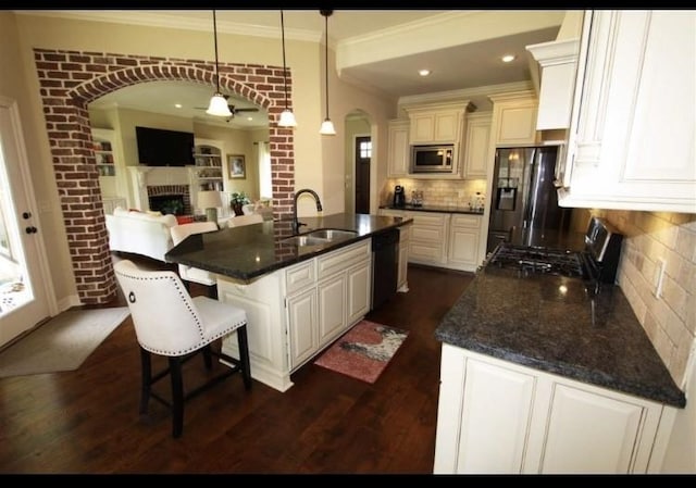 kitchen with sink, decorative light fixtures, a center island with sink, black dishwasher, and stainless steel microwave