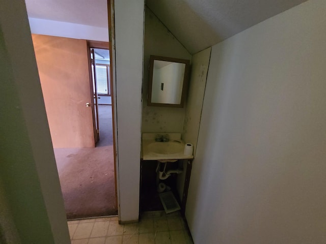 corridor featuring vaulted ceiling and sink