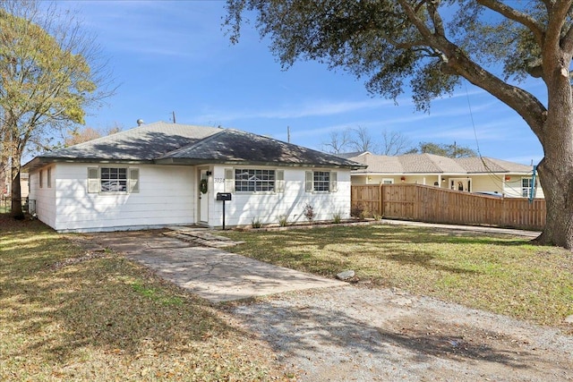 ranch-style house featuring a front yard and fence