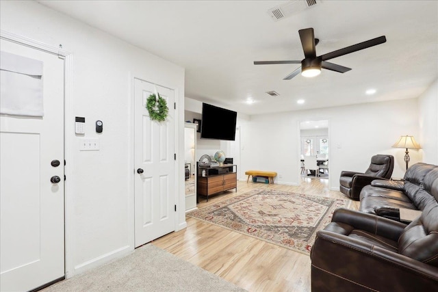 living area with a ceiling fan, recessed lighting, visible vents, and light wood finished floors