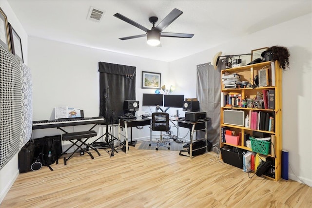 home office with a ceiling fan, baseboards, visible vents, and wood finished floors