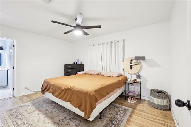 bedroom with ceiling fan, light wood-style flooring, and baseboards