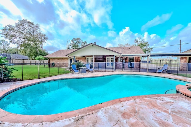 view of swimming pool featuring french doors, a patio area, and a lawn