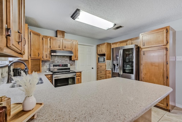 kitchen with sink, a textured ceiling, appliances with stainless steel finishes, tasteful backsplash, and kitchen peninsula