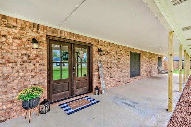 entrance to property with french doors and a porch