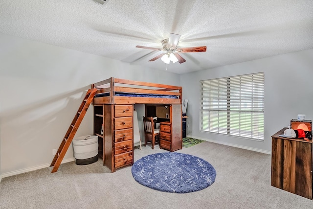 carpeted bedroom featuring ceiling fan and a textured ceiling