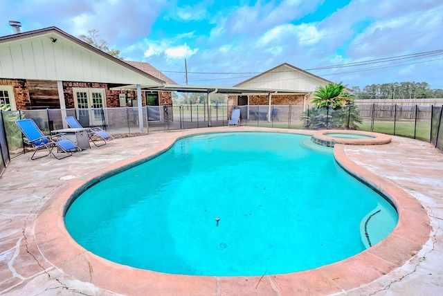 view of pool with an in ground hot tub, french doors, and a patio area