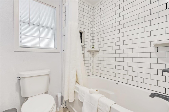 bathroom with shower / bath combination with curtain and toilet