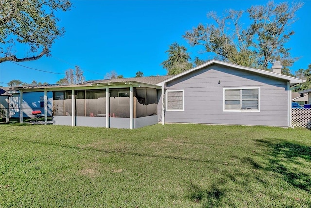 back of property featuring a lawn and a sunroom