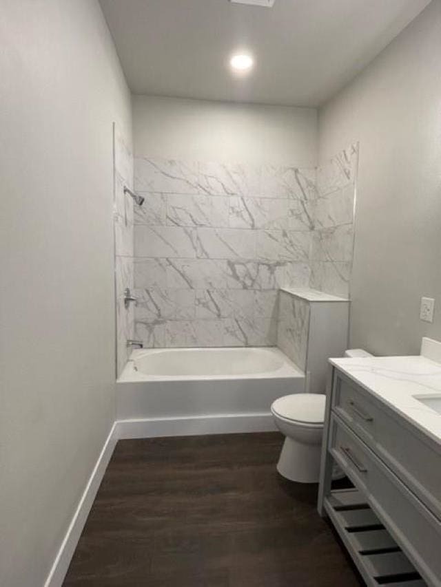 full bathroom with tiled shower / bath, wood-type flooring, vanity, and toilet