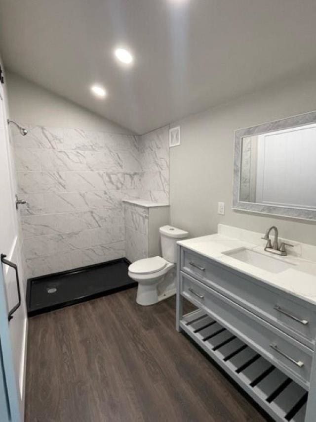 bathroom featuring vanity, hardwood / wood-style floors, toilet, and walk in shower