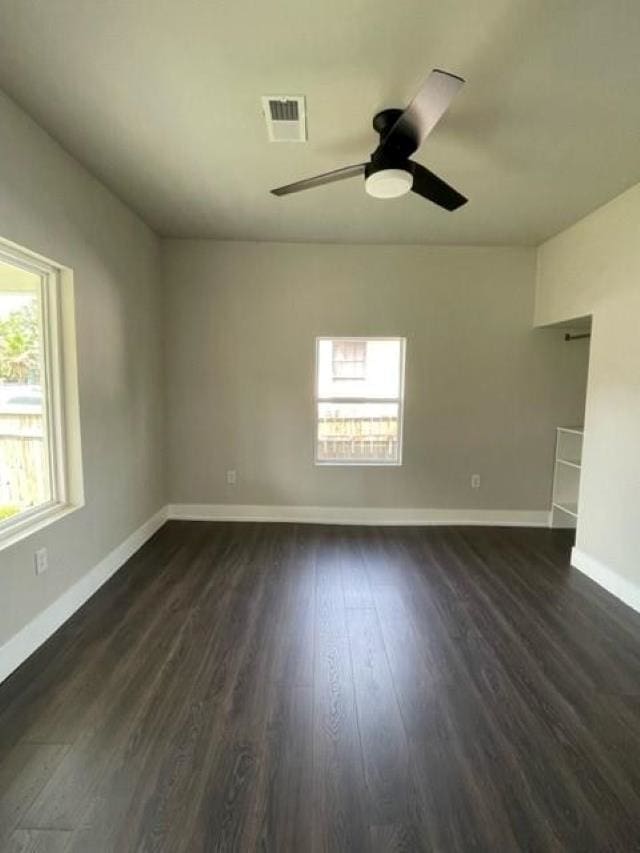 spare room with dark hardwood / wood-style flooring and ceiling fan