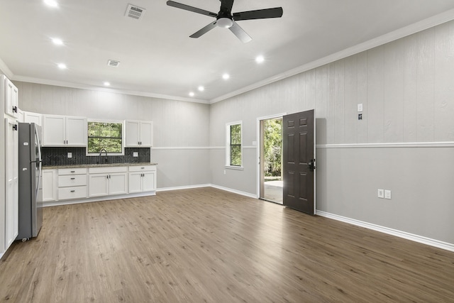 interior space featuring a healthy amount of sunlight, sink, crown molding, ceiling fan, and light hardwood / wood-style floors