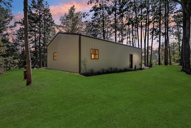 property exterior at dusk featuring a yard