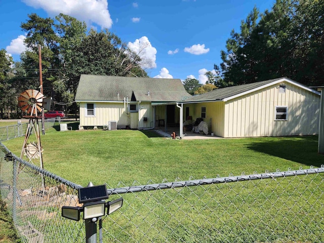 rear view of house with a yard and central air condition unit