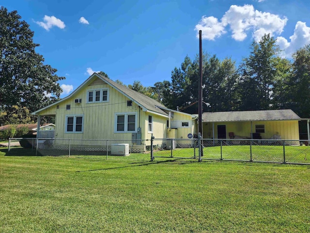 rear view of property with a lawn and central AC unit