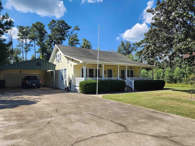 view of front of house with a front lawn, covered porch, an outdoor structure, and a garage