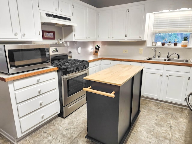 kitchen with white cabinets, appliances with stainless steel finishes, butcher block counters, and sink